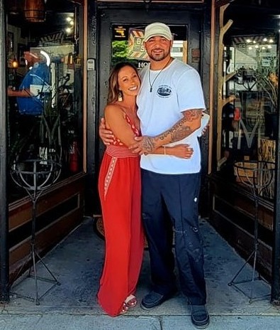 PJ and Stephanie, owners of Meraki Barbering, standing outside the barbershop in Warrensburg, NY.